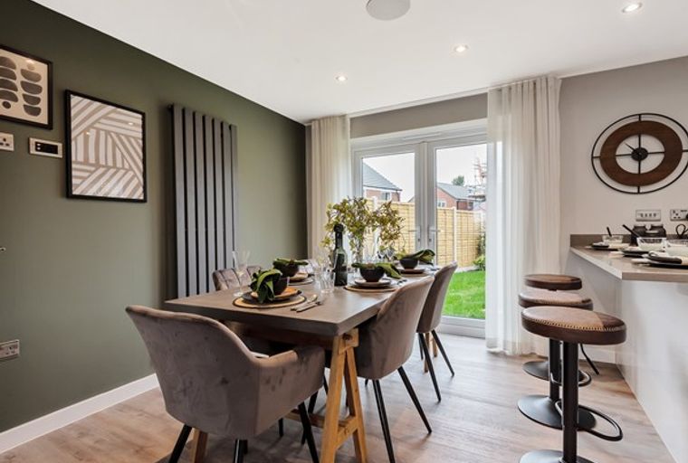 A dining room with a table, chairs, and a kitchen island with bar stools.