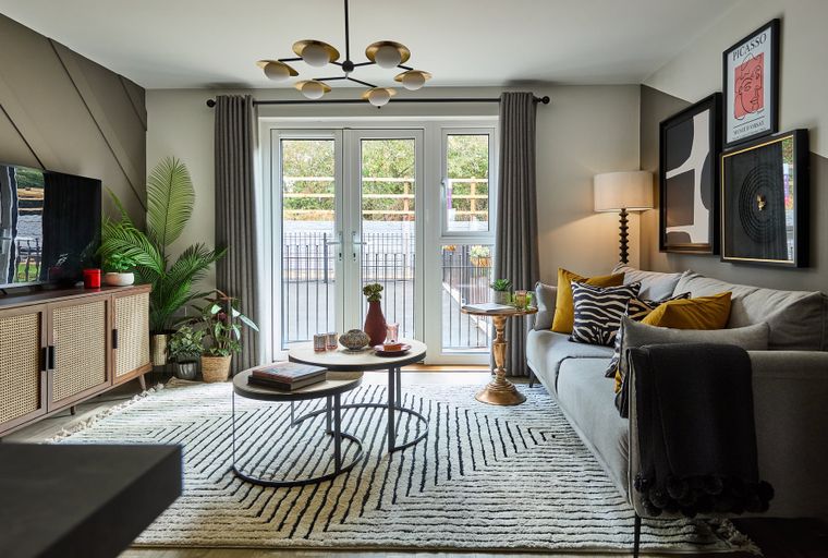 A living room with a sofa, coffee tables, a media console, and a rug.