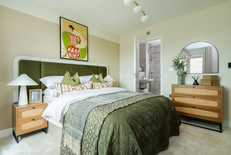 A bedroom with a bed, nightstands, a dresser, and an en-suite bathroom.