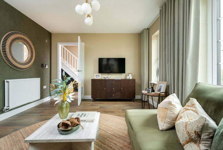 A living room with a TV, media console, sofa, coffee table, and curtains.