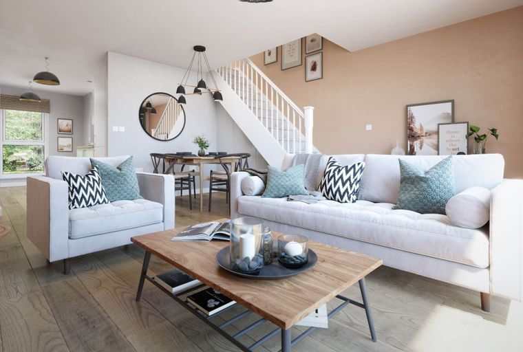 A living room and dining area with a sofa, armchair, dining table, and a staircase.