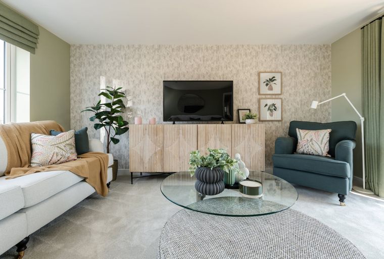 A living room with a sofa, armchair, television, and coffee table.