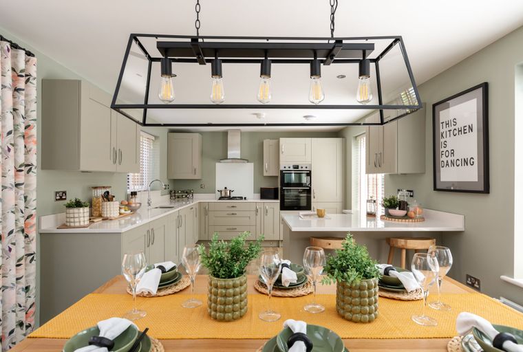 A modern kitchen and dining area with a table set for a meal.