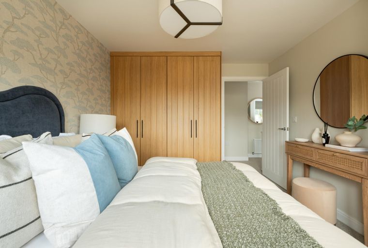 A bedroom with a bed, wardrobe, and dressing table.