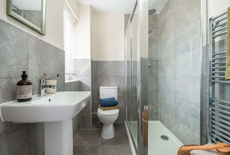 A bathroom with a sink, toilet, and shower.