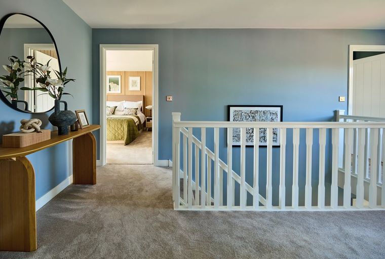 A hallway with a console table, mirror, and a doorway leading to a bedroom.