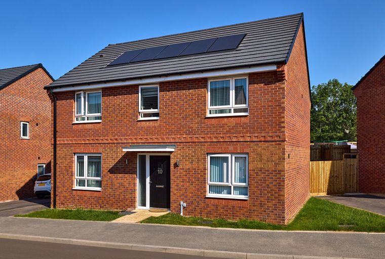 A modern brick house with solar panels on the roof and a dark front door.