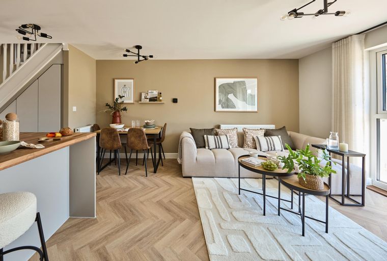 A dining area and living room with a sofa, dining table, chairs, and coffee tables.