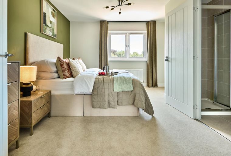 A bedroom with a bed, bedside tables, a window, and an open door to a shower.