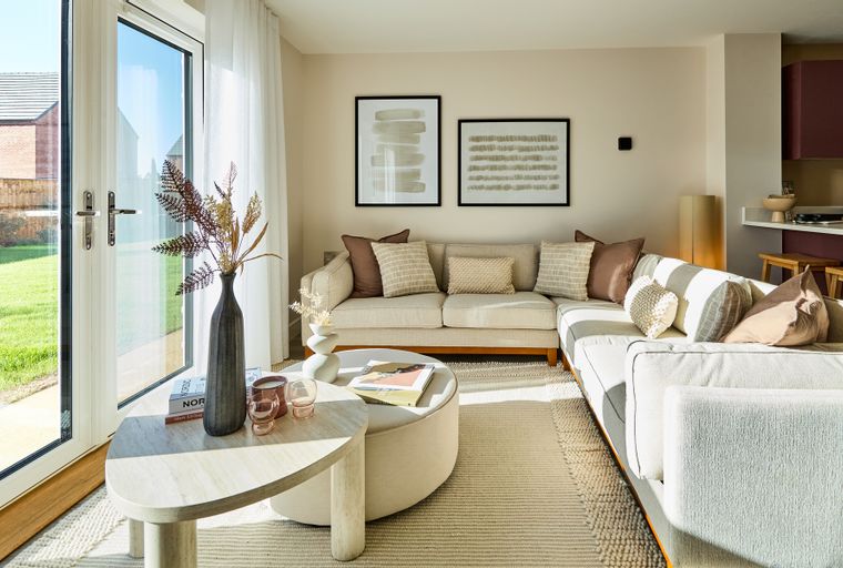 A living room with a sectional sofa, coffee table, and artwork on the wall.