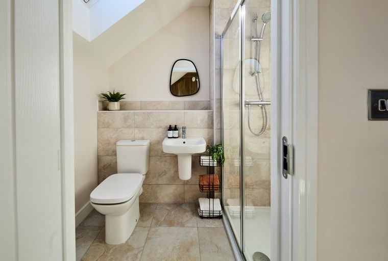 A bathroom with a toilet, sink, and shower.