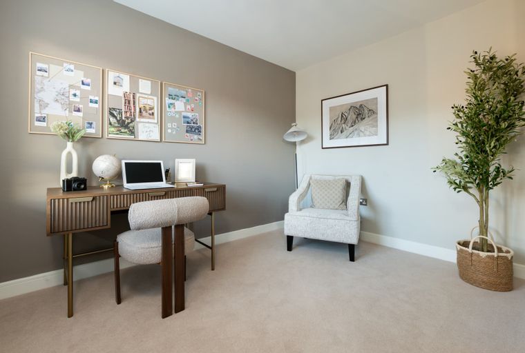 A home office with a desk, chair, and armchair.