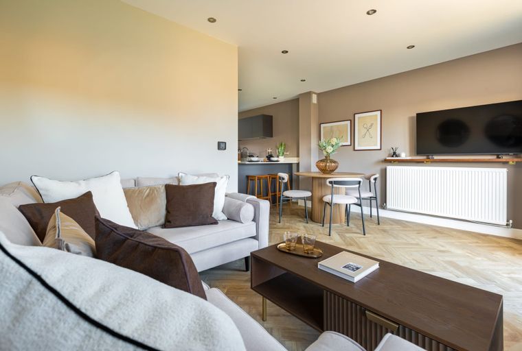 A living room and dining area with a sofa, coffee table, dining table, and chairs.