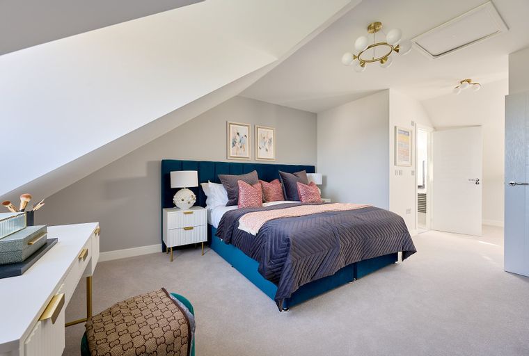 A bedroom with a bed, nightstands, a dresser, and a chair.