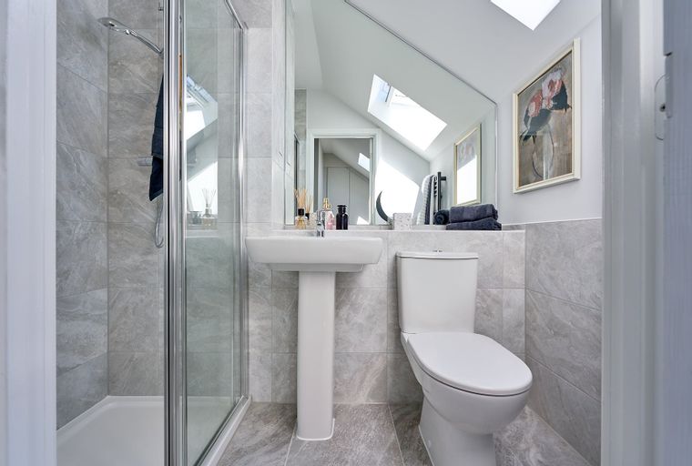 A bathroom with a shower, sink, and toilet.