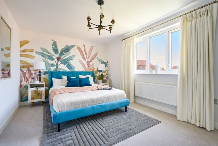 A bedroom with a bed, nightstand, and a window.