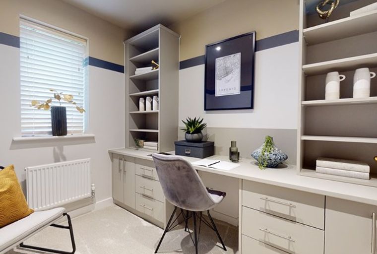 A home office with a desk, chair, and shelving unit.