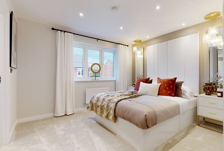 A bedroom with a bed, bedside tables, and a window.