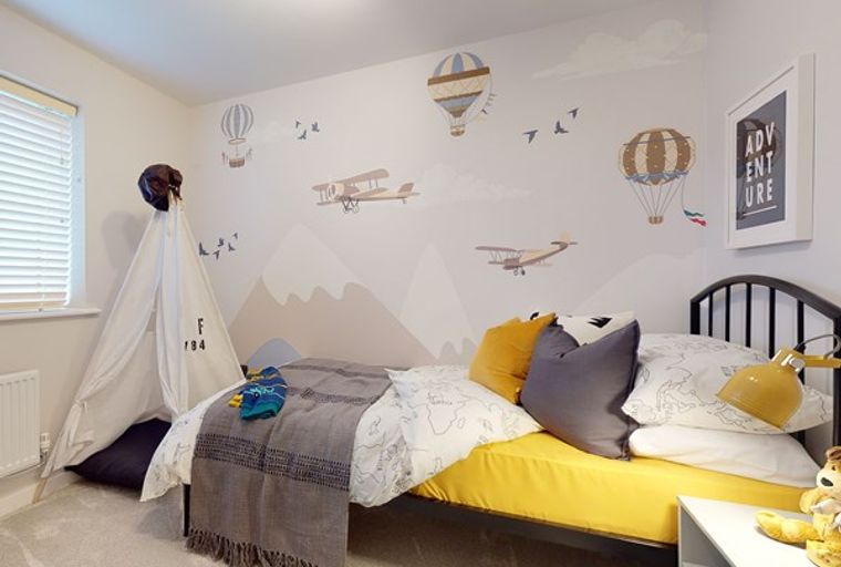 A child's bedroom with a bed, a teepee, and wall decals of airplanes and hot air balloons.