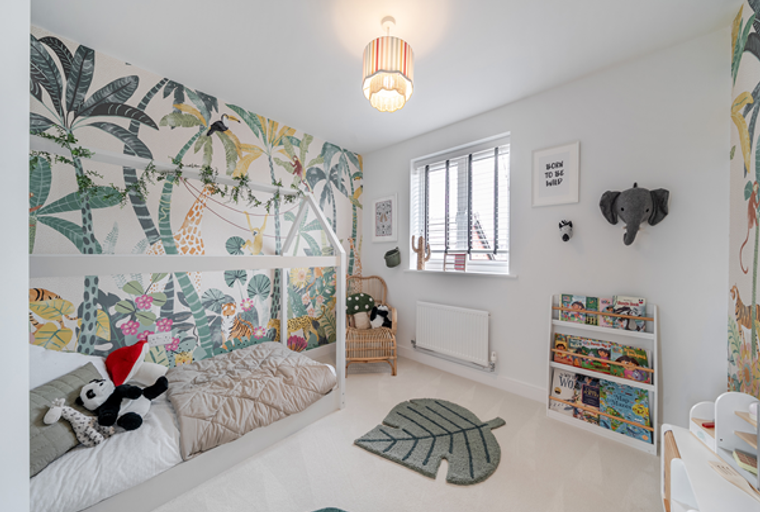 A child's bedroom with jungle-themed wallpaper, a house-shaped bed, and a bookshelf.