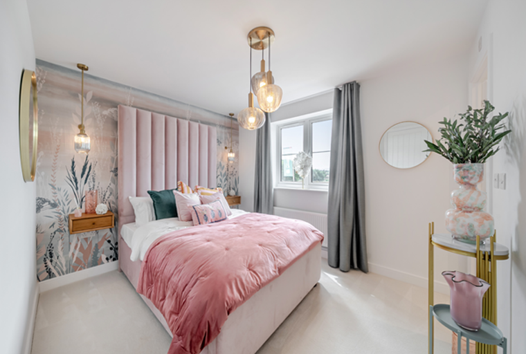 A bedroom with a bed, wallpaper, and pendant lights.