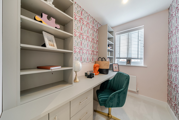 A home office with a desk, chair, and bookshelf.