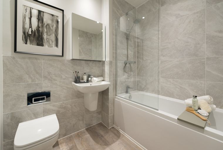 A bathroom with a toilet, sink, and bathtub with a shower.