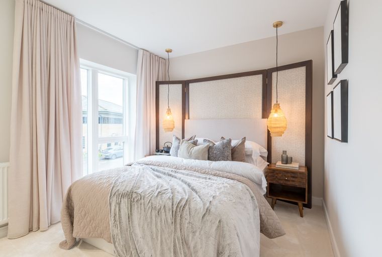 A bedroom with a bed, curtains, and pendant lights.
