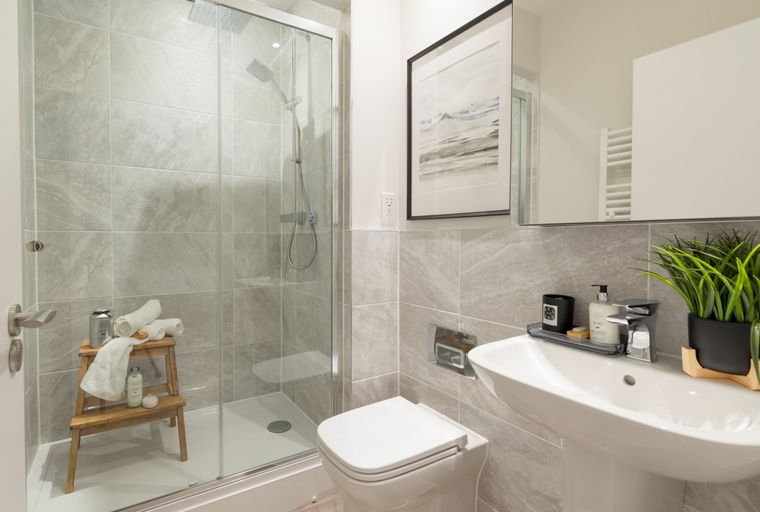 A bathroom with a shower, toilet, and sink.