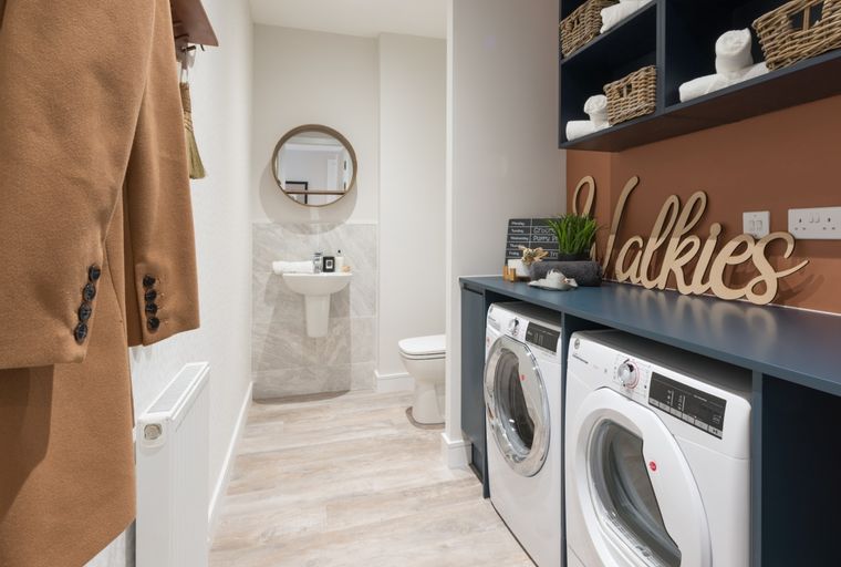 A laundry room with a washing machine, dryer, and a small bathroom area.