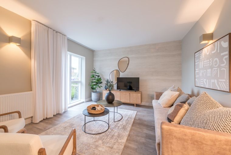 A living room with a sofa, coffee tables, and a television.