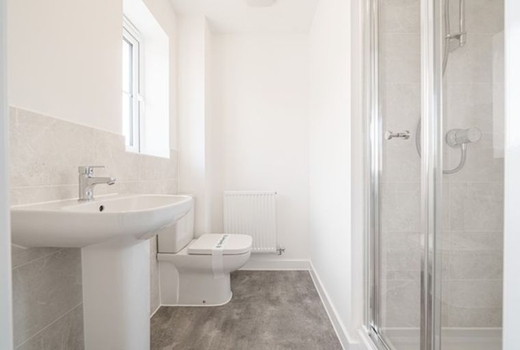 A bathroom with a sink, toilet, and shower.