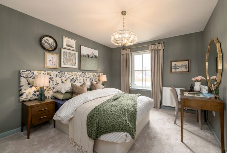 A bedroom with a bed, bedside tables, a window, and a vanity desk.