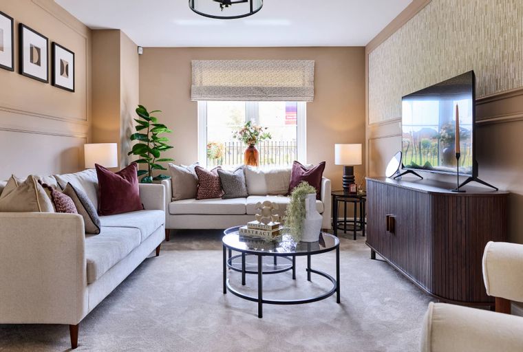A living room with a sofa, coffee table, and television.