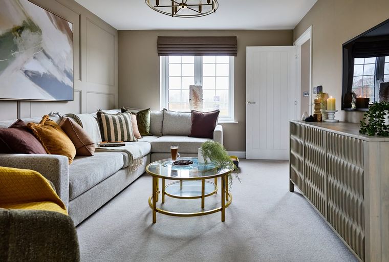 A living room with a sectional sofa, coffee table, and a large window.