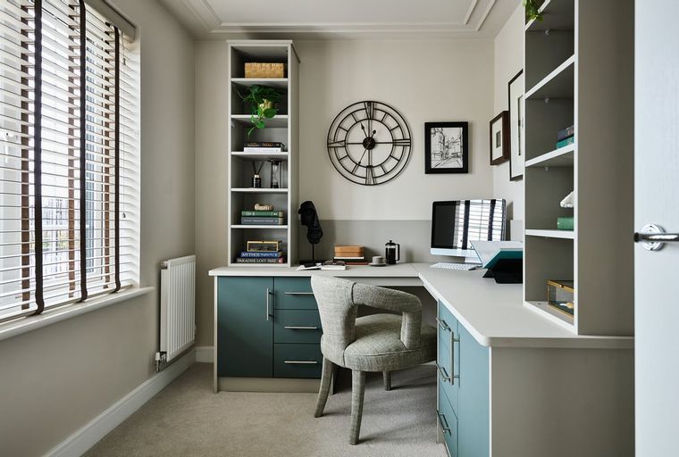 A home office with a desk, chair, computer, and shelves.