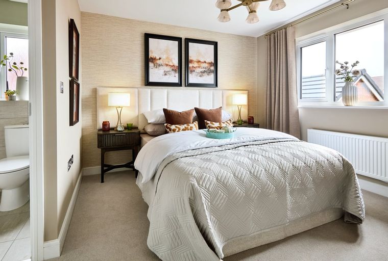 A bedroom with a bed, bedside tables, lamps, and a window.