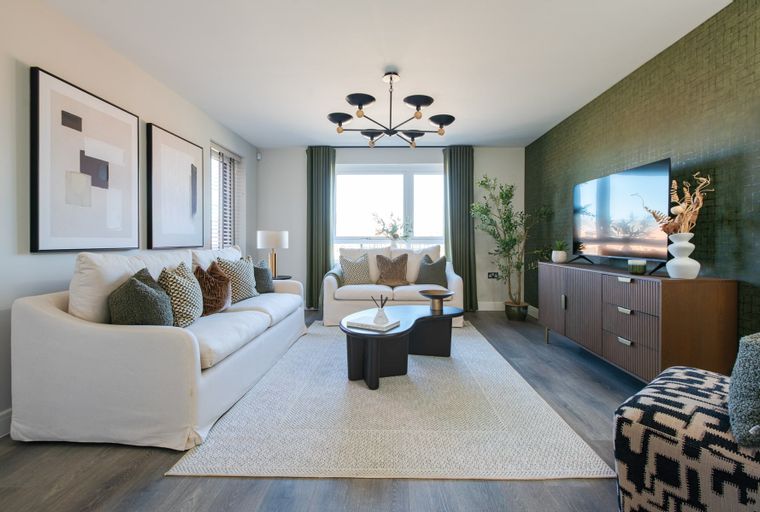 A living room with two sofas, a coffee table, a television, and a chandelier.