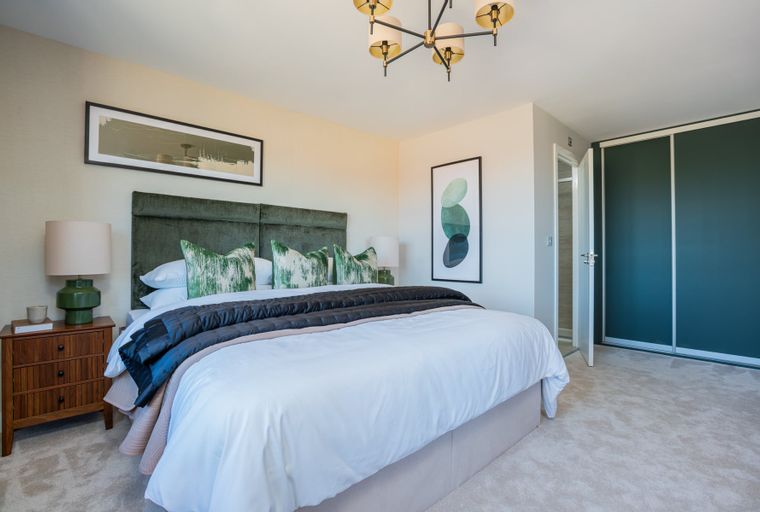 A bedroom with a bed, nightstand, and a wardrobe.