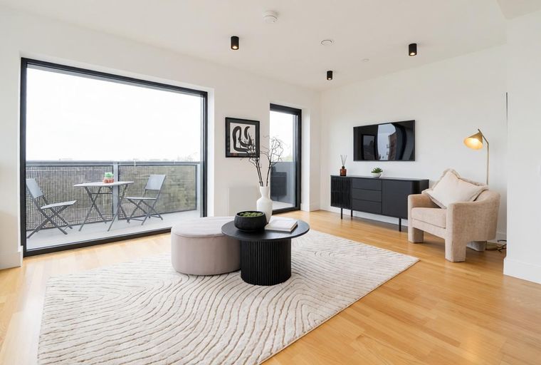 A living room with a coffee table, rug, armchair, and a television.