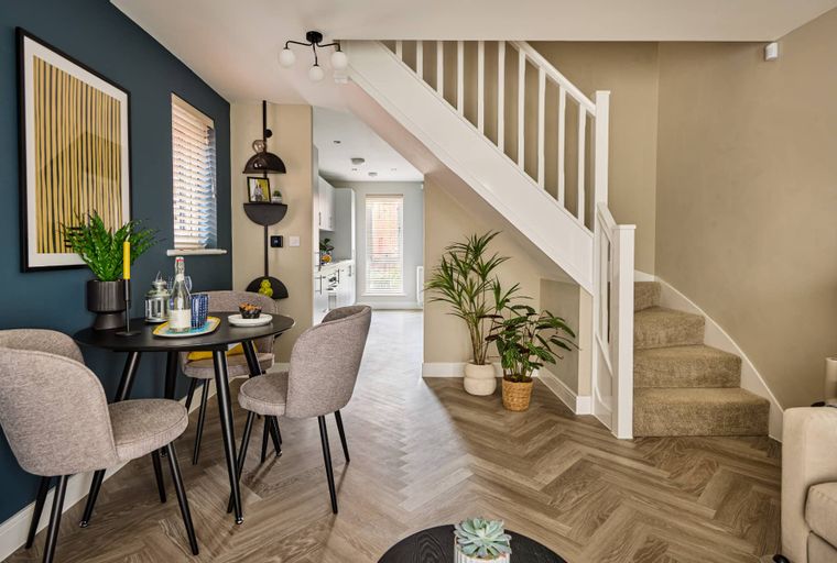 A dining area with a table and chairs next to a staircase.