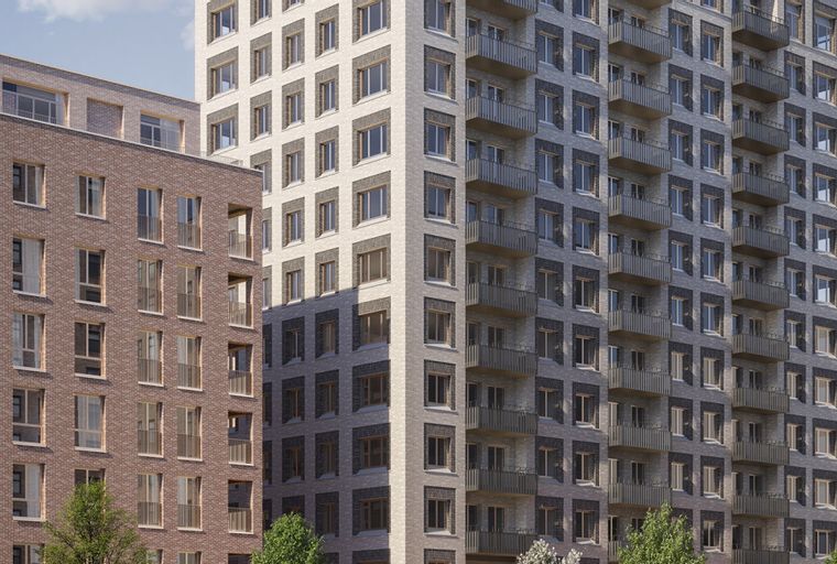 A modern apartment building with brick and light-colored masonry facades, featuring numerous windows and balconies.