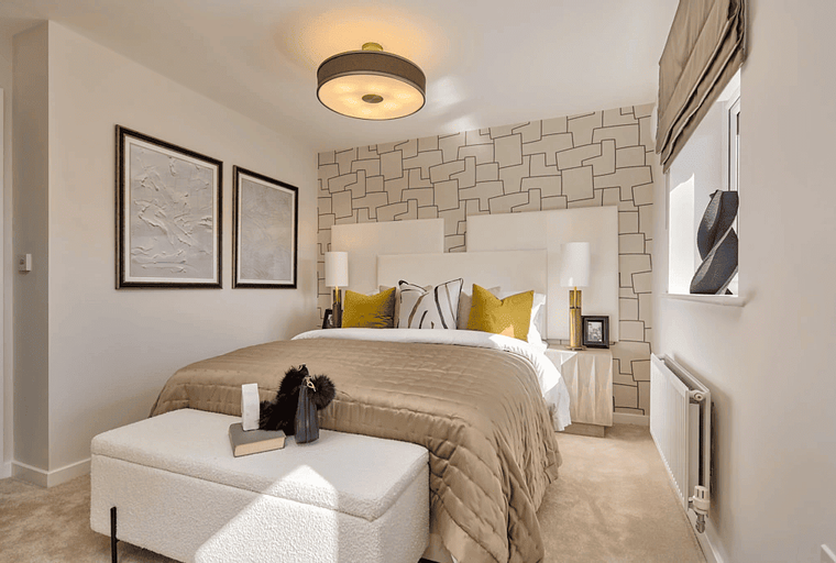 A bedroom with a bed, bedside tables, artwork, and a bench.