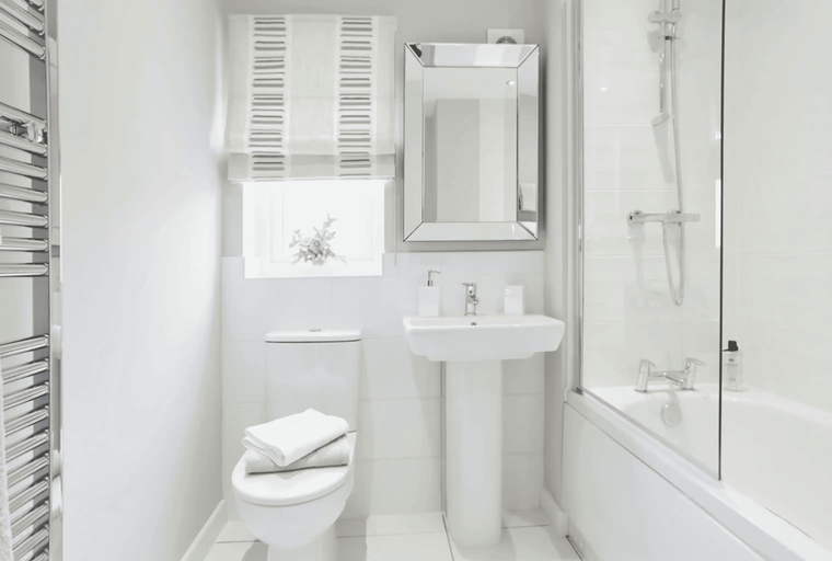 A bathroom with a toilet, sink, and bathtub.