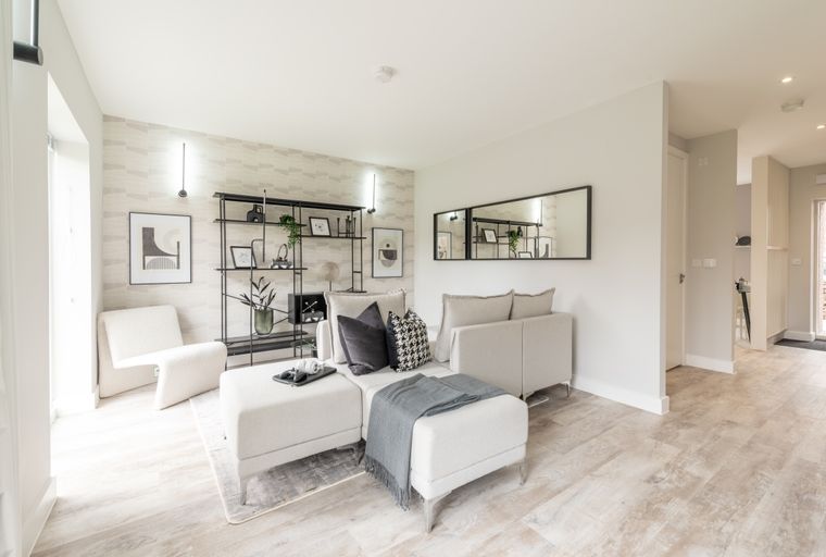 A living room with a sectional sofa, an accent chair, and a shelving unit.