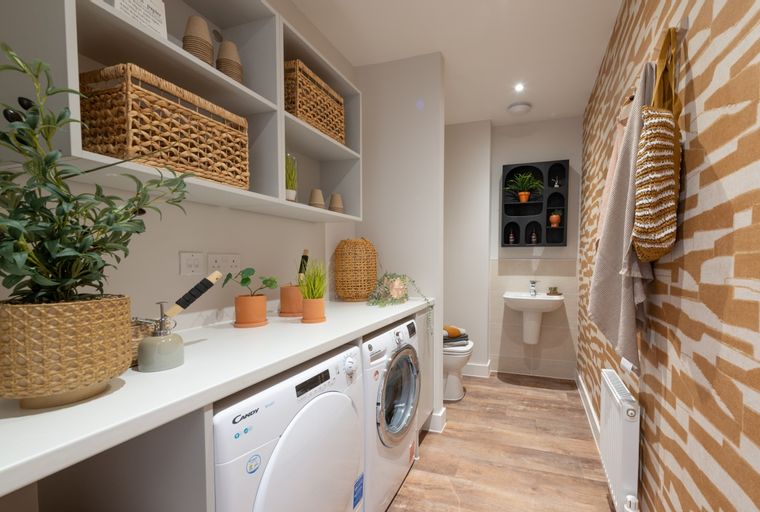 A laundry room with a washing machine, dryer, sink, and toilet.