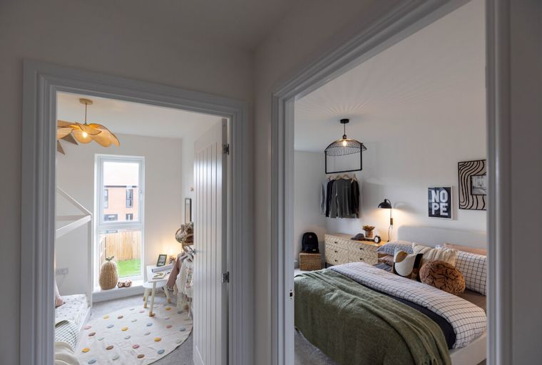 A view into two rooms, one a child's room and the other a bedroom.
