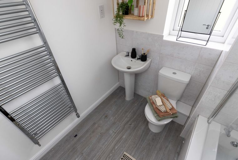 A bathroom with a sink, toilet, and towel warmer.