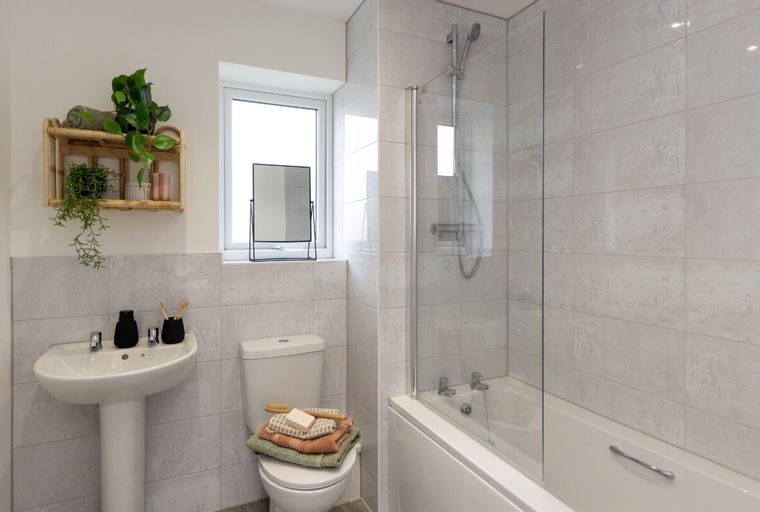 A bathroom with a sink, toilet, and bathtub with a shower.