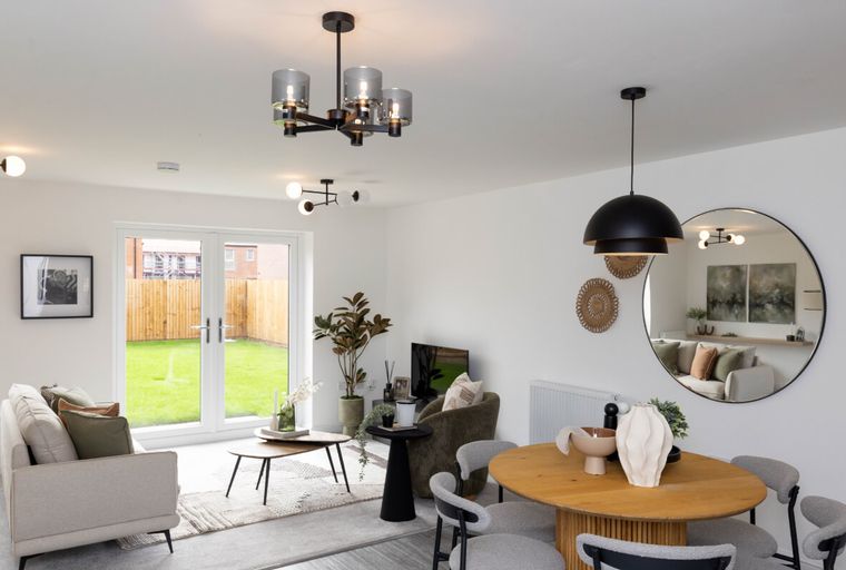 A living and dining area with a sofa, coffee table, dining table, and chairs.